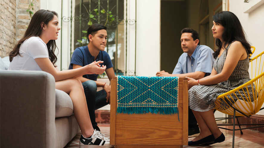 A middle aged man and woman gather around a table with a young adult man and woman