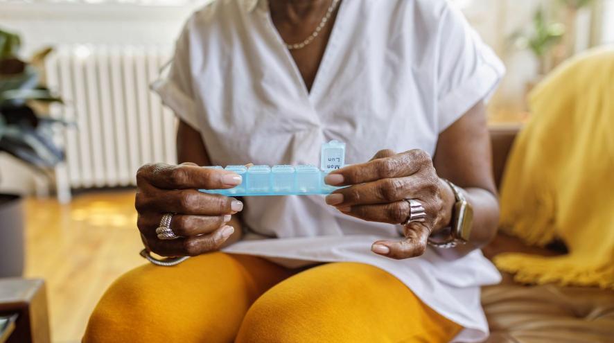 Woman holding a pill organizer box