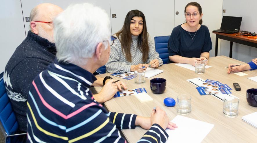 A group sat around a table, learning and discussing.