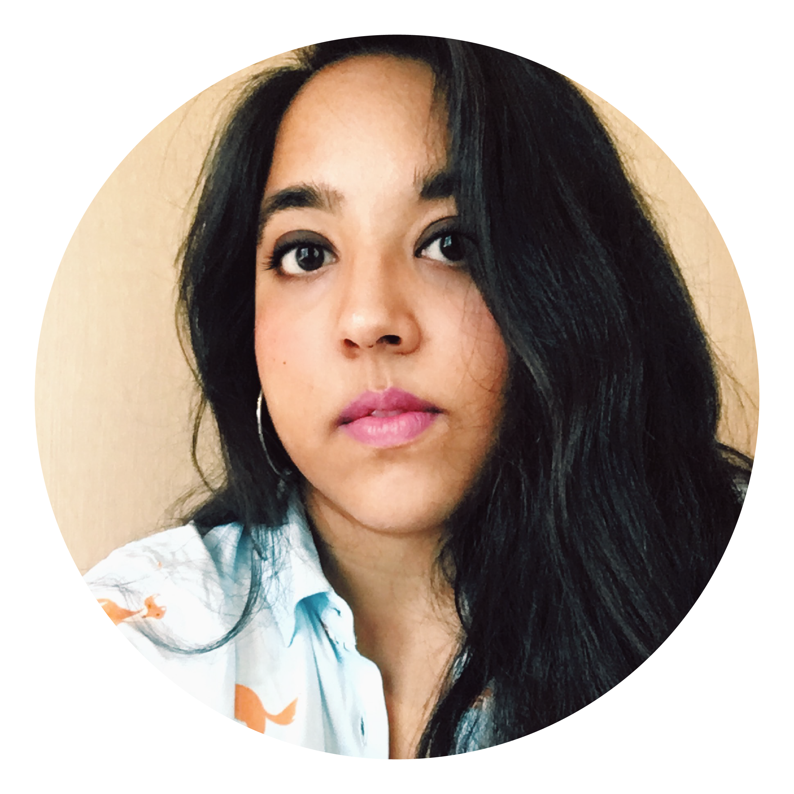 A woman with long dark hair, a multicoloured shirt and silver earrings