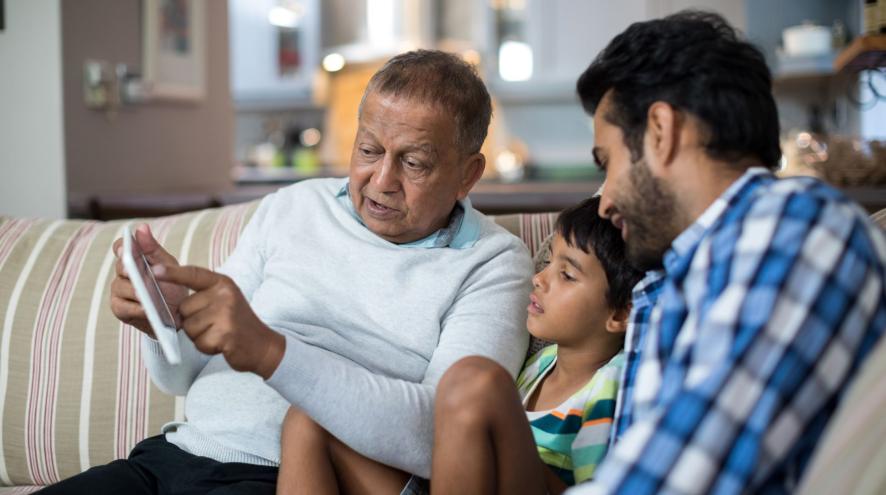  A senior man showing a boy and young man information on a tablet