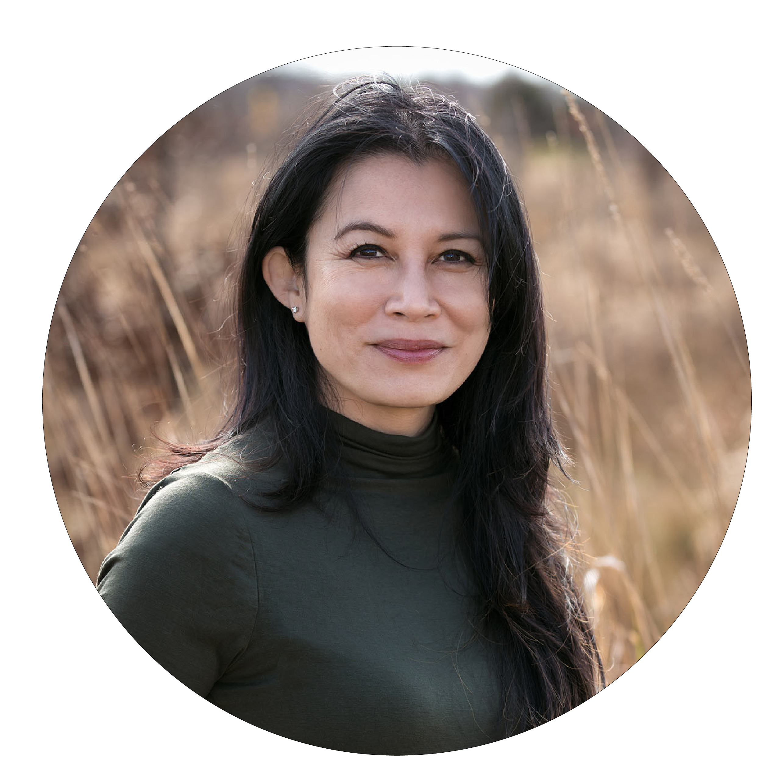 Woman with long black hair and green shirt smiling outdoors