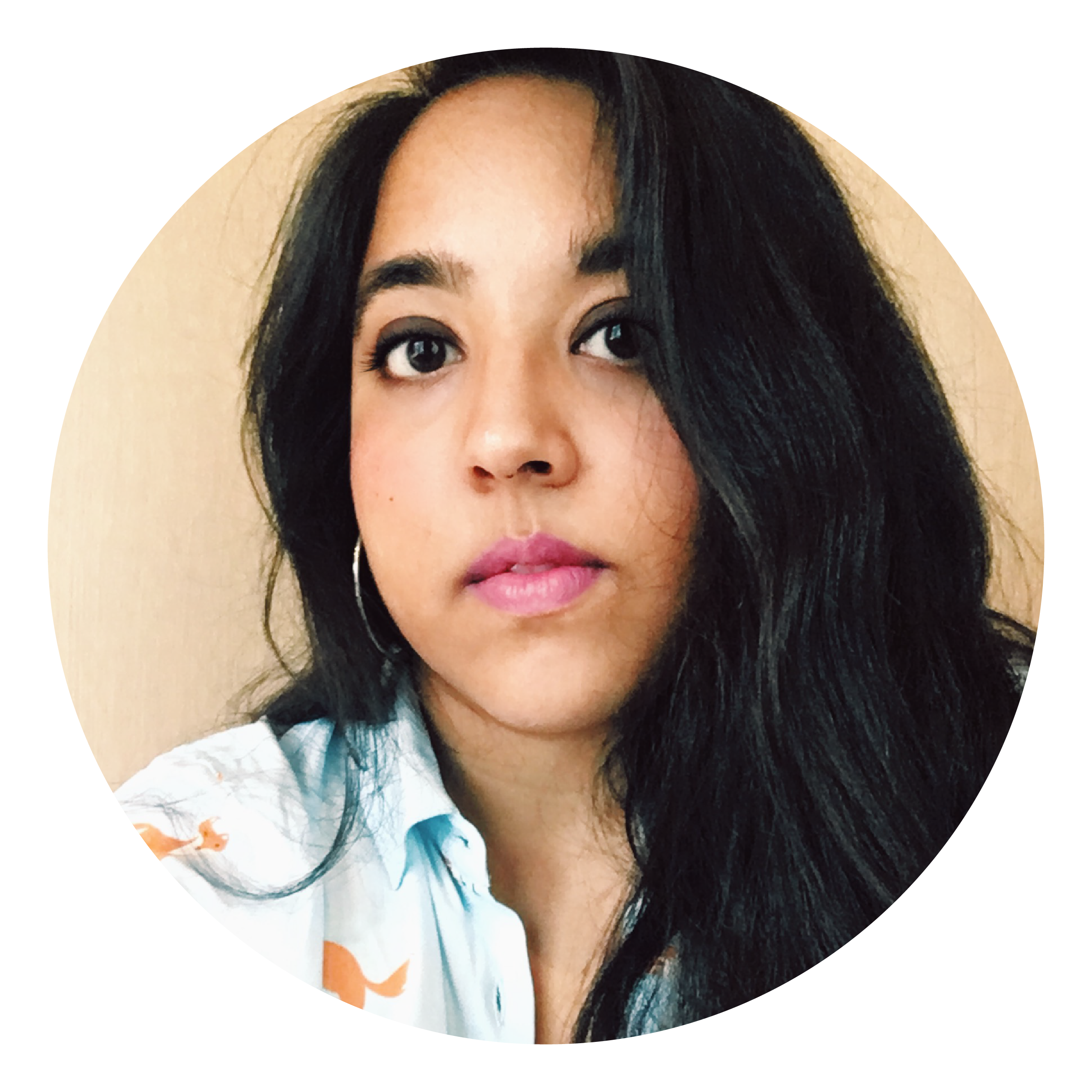 A woman with long dark hair, a multicoloured shirt and silver earrings