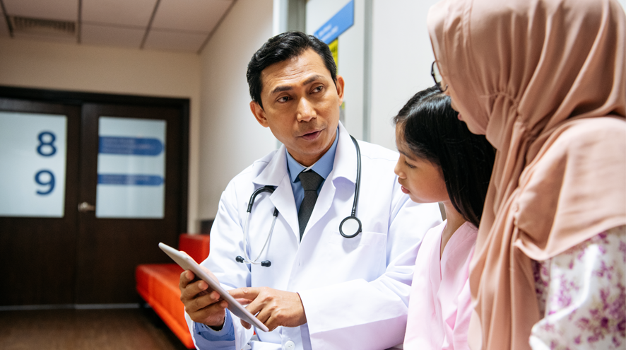 Doctor explaining something to a girl and to a woman wearing a hijab 