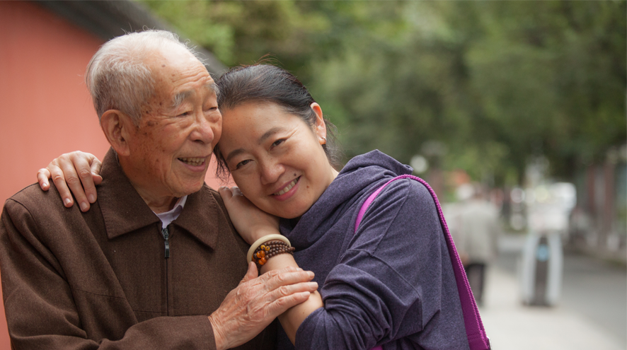 A younger woman embraces an older male relative