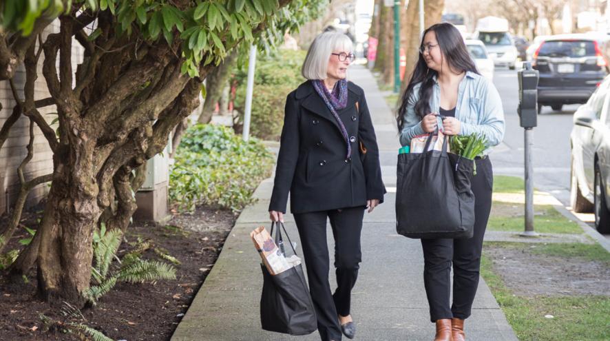 Two woman walking with groceries