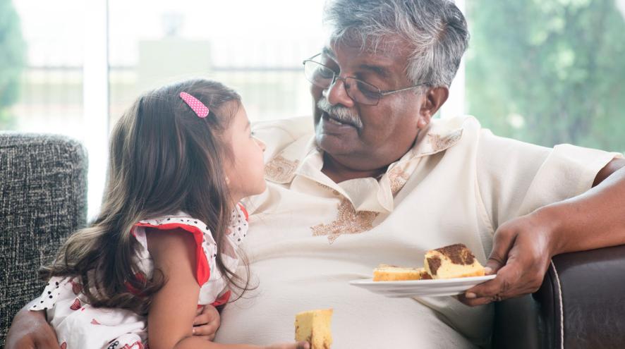 Older man talks to his granddaughter on couch