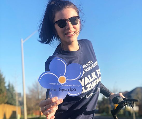 Young woman on her bike holding a flower in memory of her grandpa.