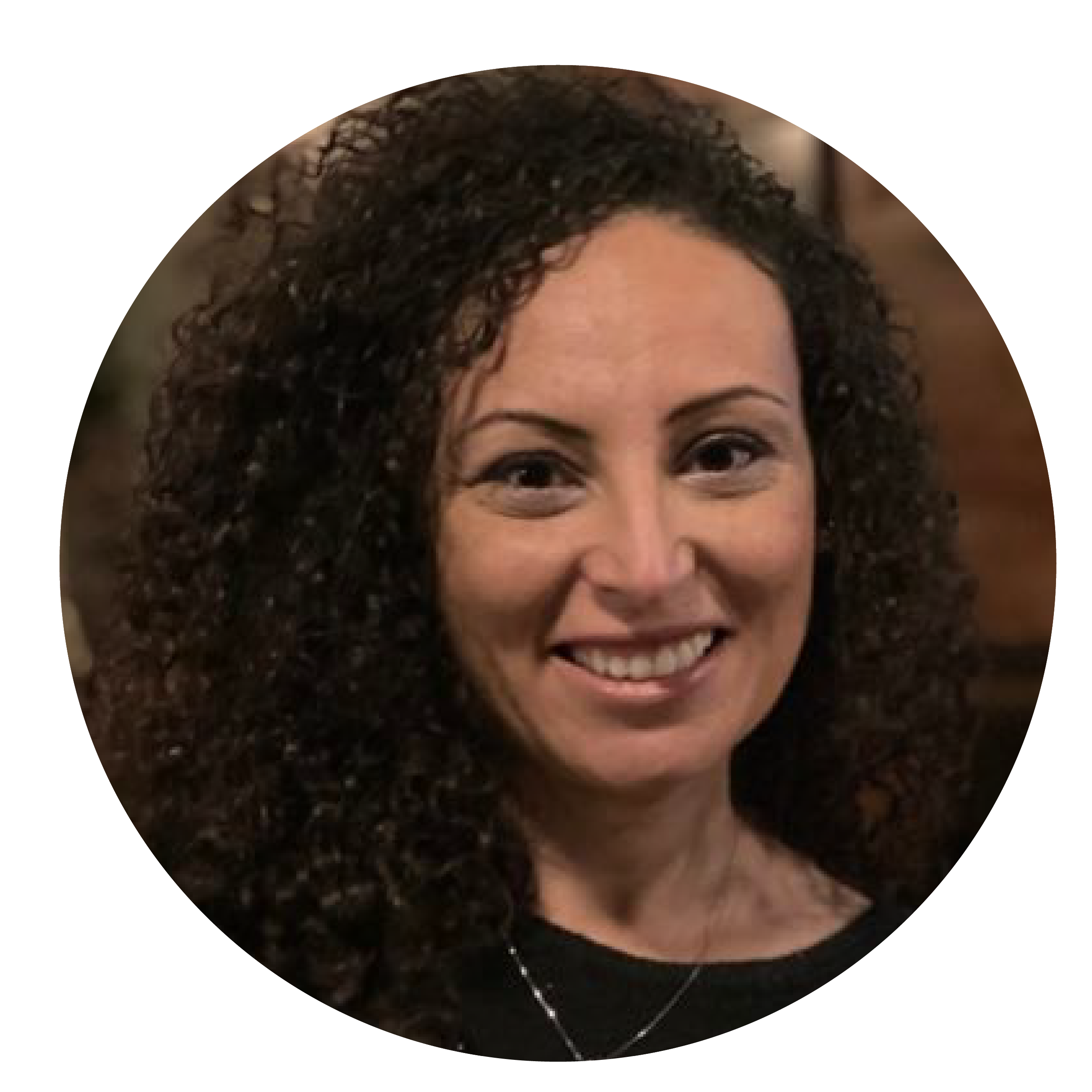 A smiling woman with brown eyes and brown curly hair