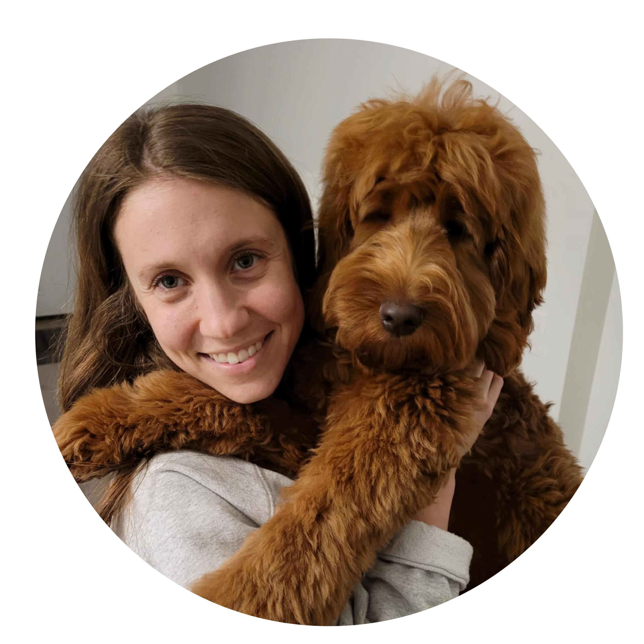 A woman with straight brown hair smiles next to a medium-sized brown dog