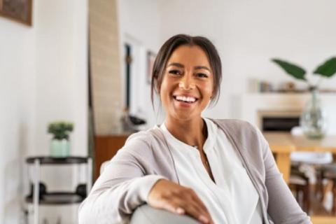 woman sitting on a couch looking at the camera and smiling