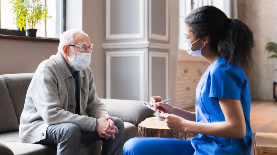 Older man with glasses and younger health care professional