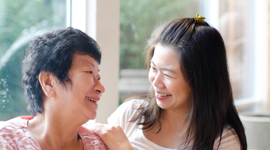 Two women talking, one older, with younger one touching older's shoulder