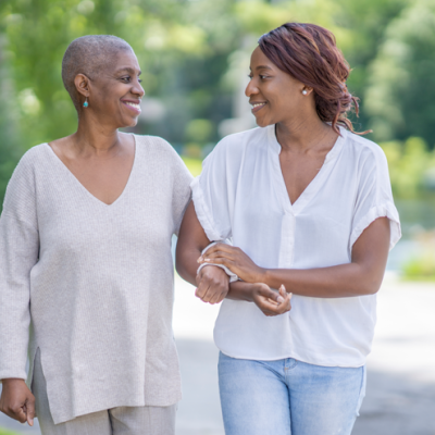 Two happy women holding hands, walking and smiling